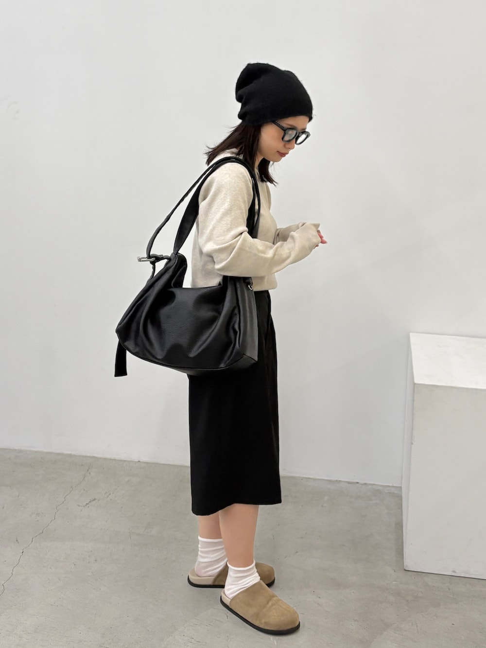 ホワイト系のニット/セーター、ブラック系のショルダーバッグ、ブラック系のその他パンツを着用したレディースの秋コーディネートの2枚目の写真