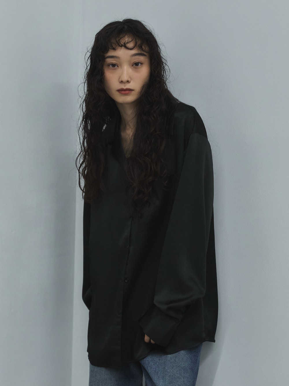 ブラック系のシャツ/ブラウス、ブルー系のデニムパンツ、ブラウン系のスニーカーを着用したレディースの秋コーディネートの4枚目の写真