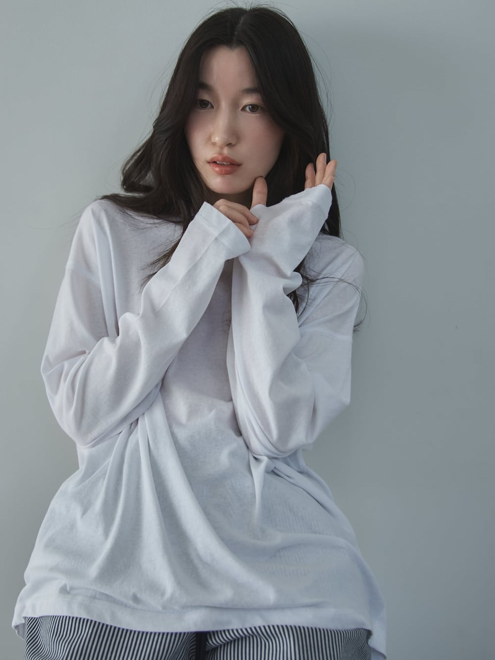 ホワイト系のTシャツ/カットソー、ホワイト系のデニムパンツ、ベージュ系のサンダルを着用したレディースの冬コーディネートの7枚目の写真