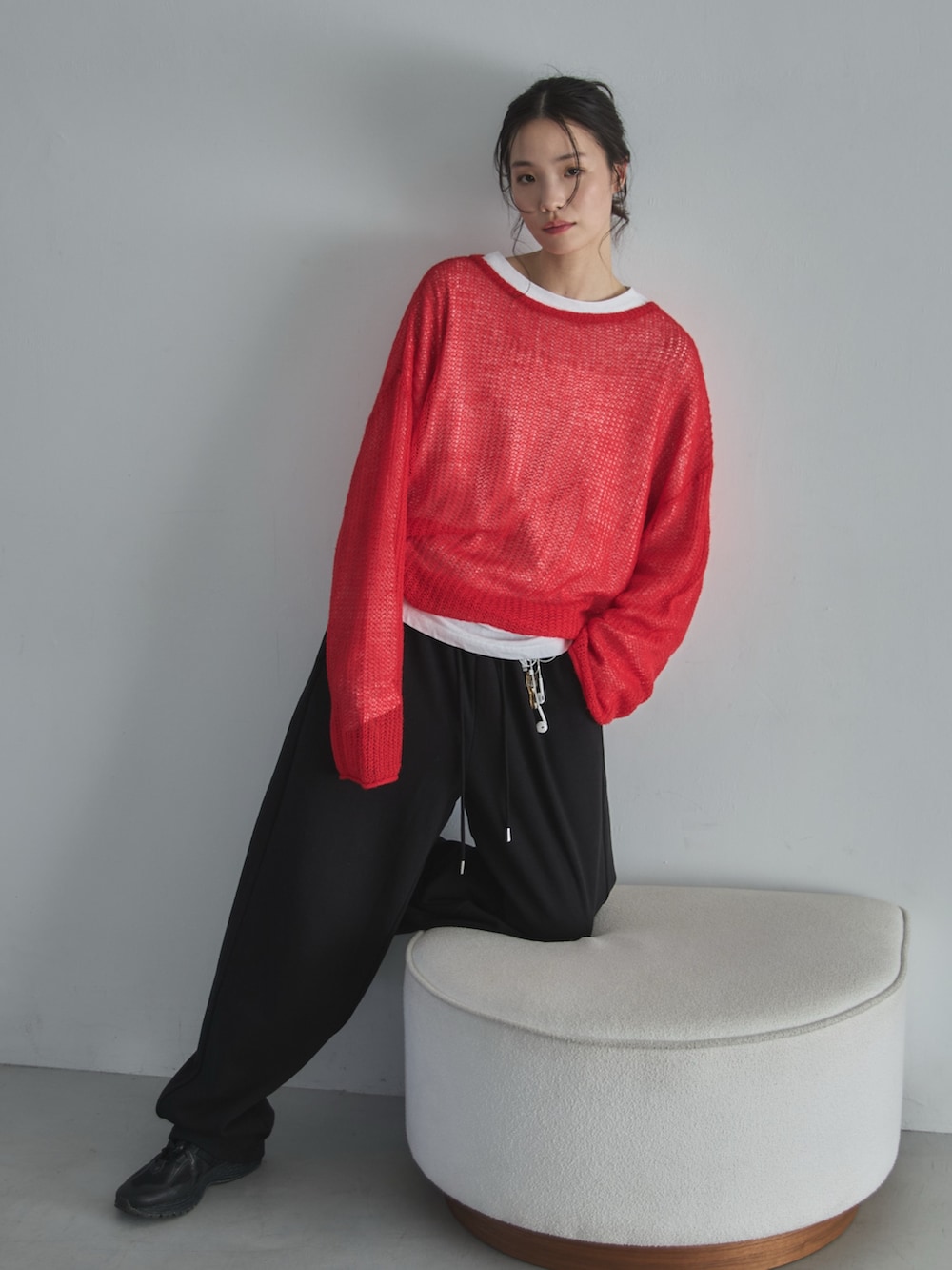 ホワイト系のTシャツ/カットソー、レッド系のニット/セーター、ブラック系のスウェットパンツを着用したレディースの冬コーディネートの6枚目の写真