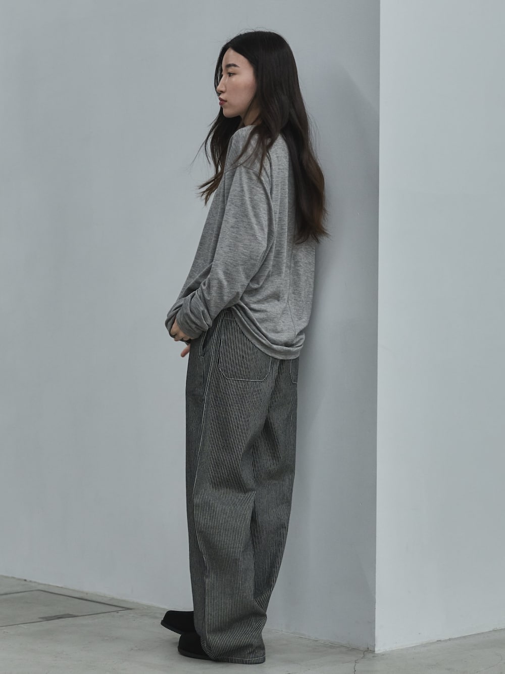 ブラック系のデニムパンツ、ブラック系のその他シューズ、グレー系のTシャツ/カットソーを着用したレディースの秋コーディネートの2枚目の写真