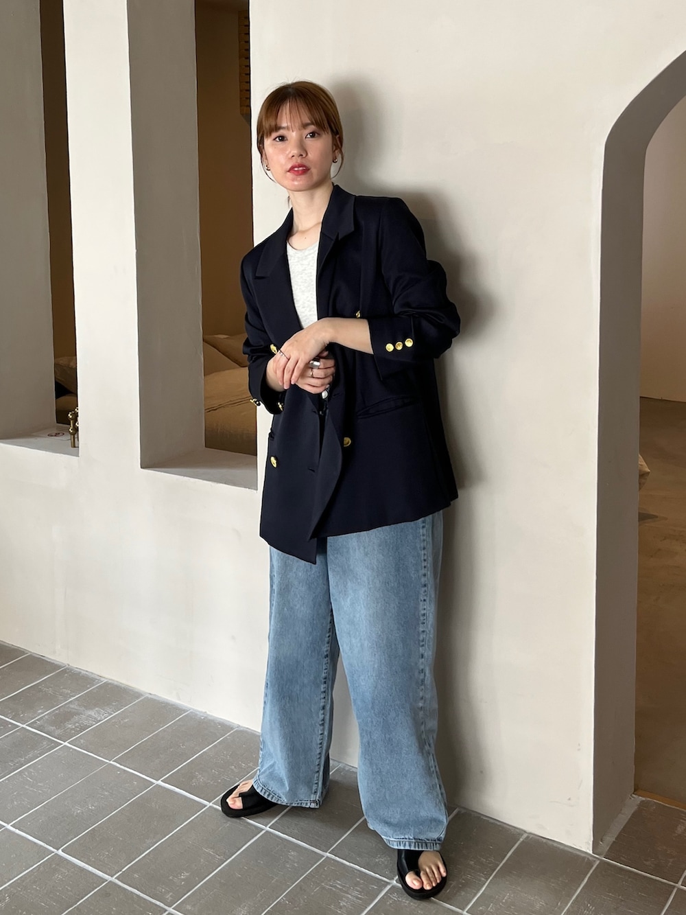 ブルー系のテーラードジャケット、ベージュ系のタンクトップ、グレー系のスラックスを着用したレディースの春コーディネートの3枚目の写真