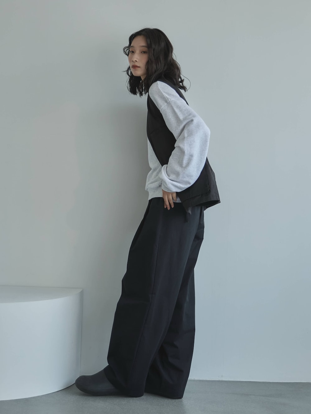 ブラック系のその他パンツ、ブラック系のベスト、ベージュ系のスウェットを着用したレディースの秋コーディネートの2枚目の写真