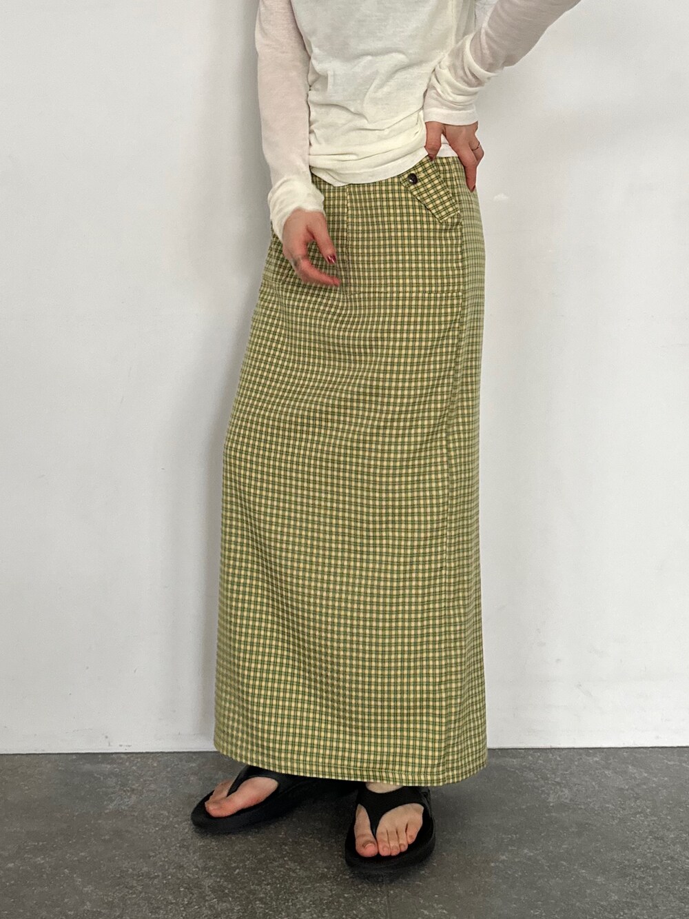 ホワイト系のTシャツ/カットソー、イエロー系のスカート、ブラック系のサンダルを着用したレディースの春コーディネートの4枚目の写真