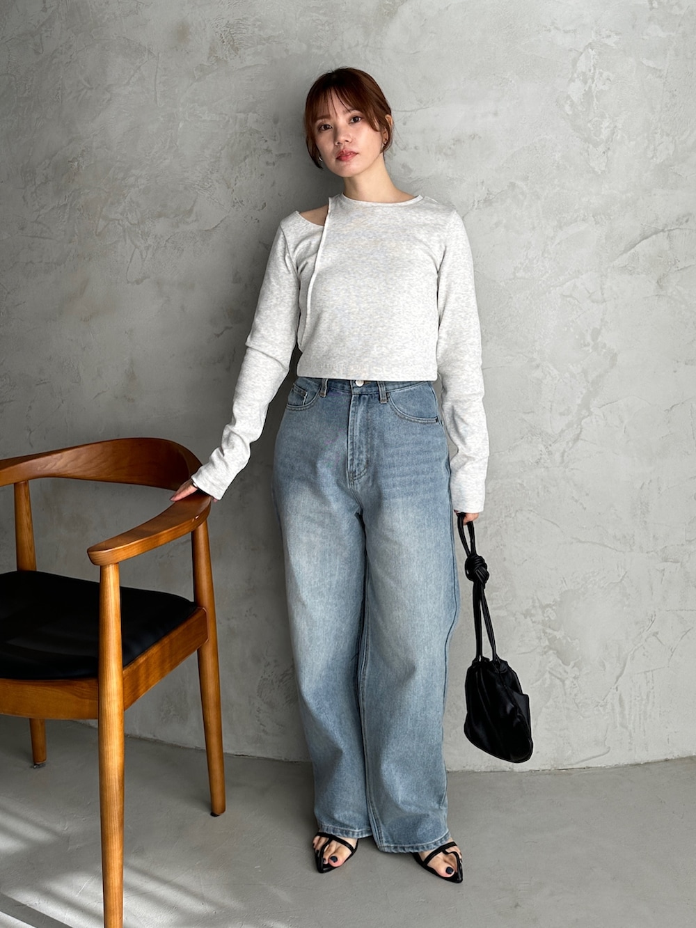 ベージュ系のTシャツ/カットソー、ブルー系のデニムパンツ、ブラック系のショルダーバッグを着用したレディースの冬コーディネートの2枚目の写真