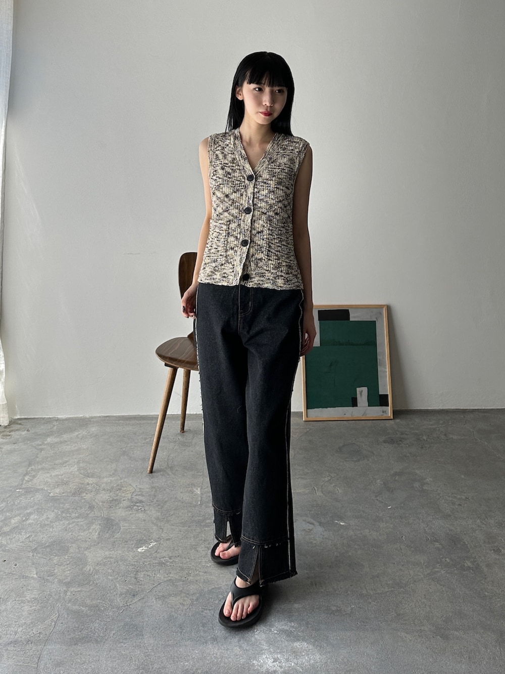 ブラック系のベスト、ブラック系のデニムパンツ、ブラック系のサンダルを着用したレディースの夏コーディネートの2枚目の写真