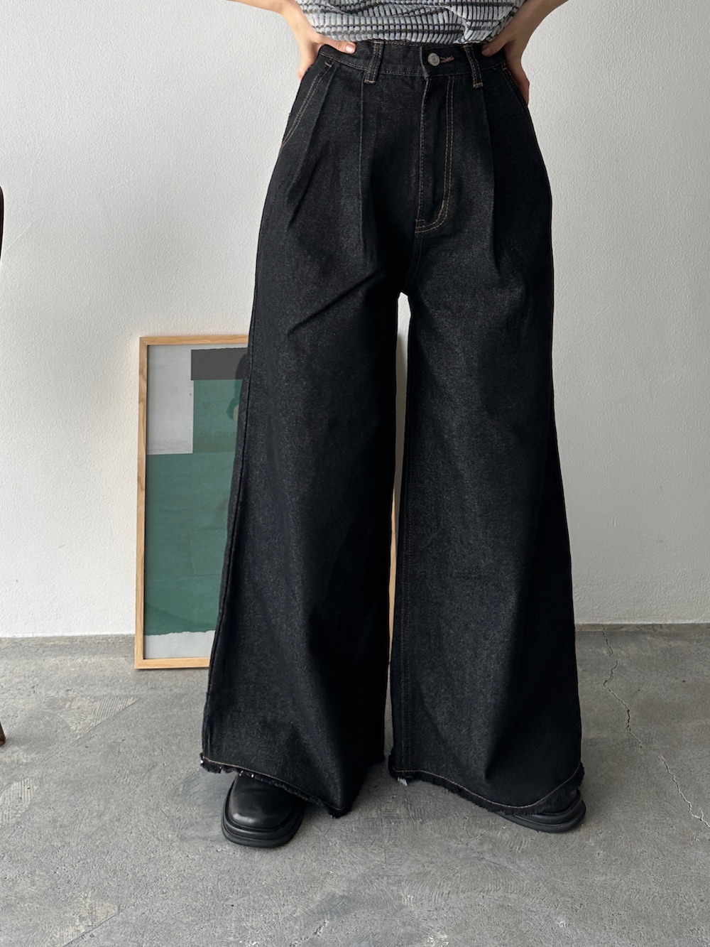 ブラック系のニット/セーター、ブラック系のデニムパンツ、ブラック系のスリッポンを着用したレディースの夏コーディネートの3枚目の写真