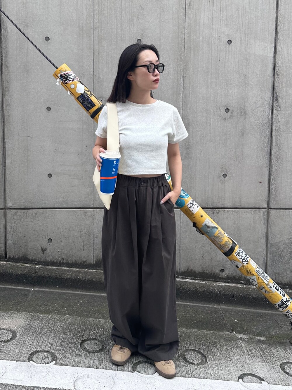 ベージュ系のTシャツ/カットソー、ブラウン系のその他パンツ、ベージュ系のスニーカーを着用したレディースの夏コーディネートの2枚目の写真