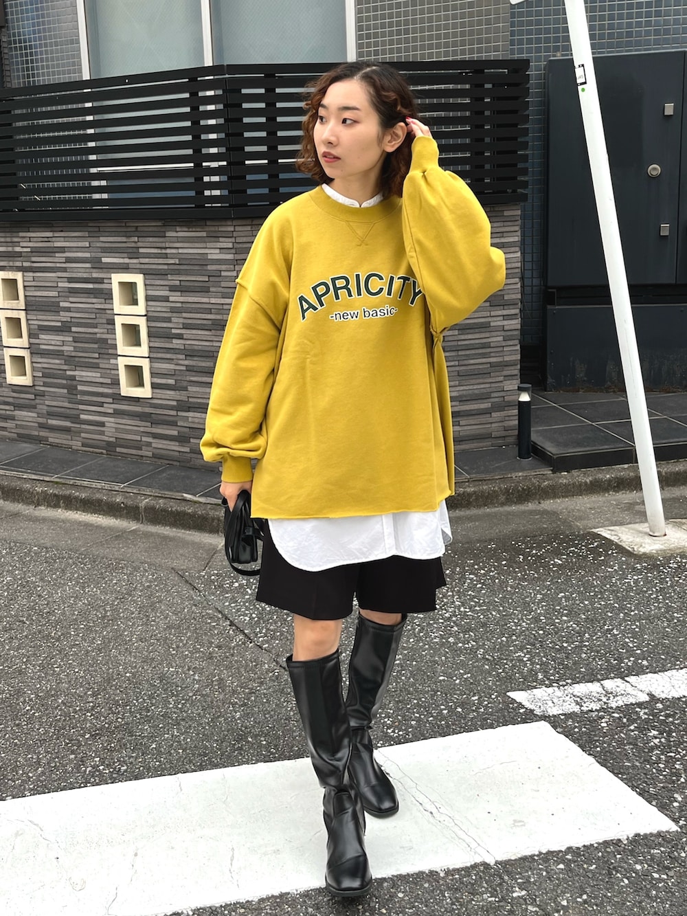 イエロー系のスウェット、ブラック系のその他パンツ、その他のその他を着用したレディースの冬コーディネートの2枚目の写真