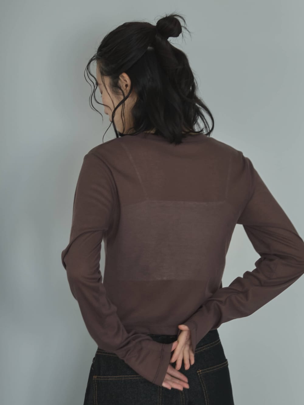 ブラウン系のカーディガン/ボレロ、ホワイト系のキャミソール、ブラック系のデニムパンツを着用したレディースの春コーディネートの5枚目の写真