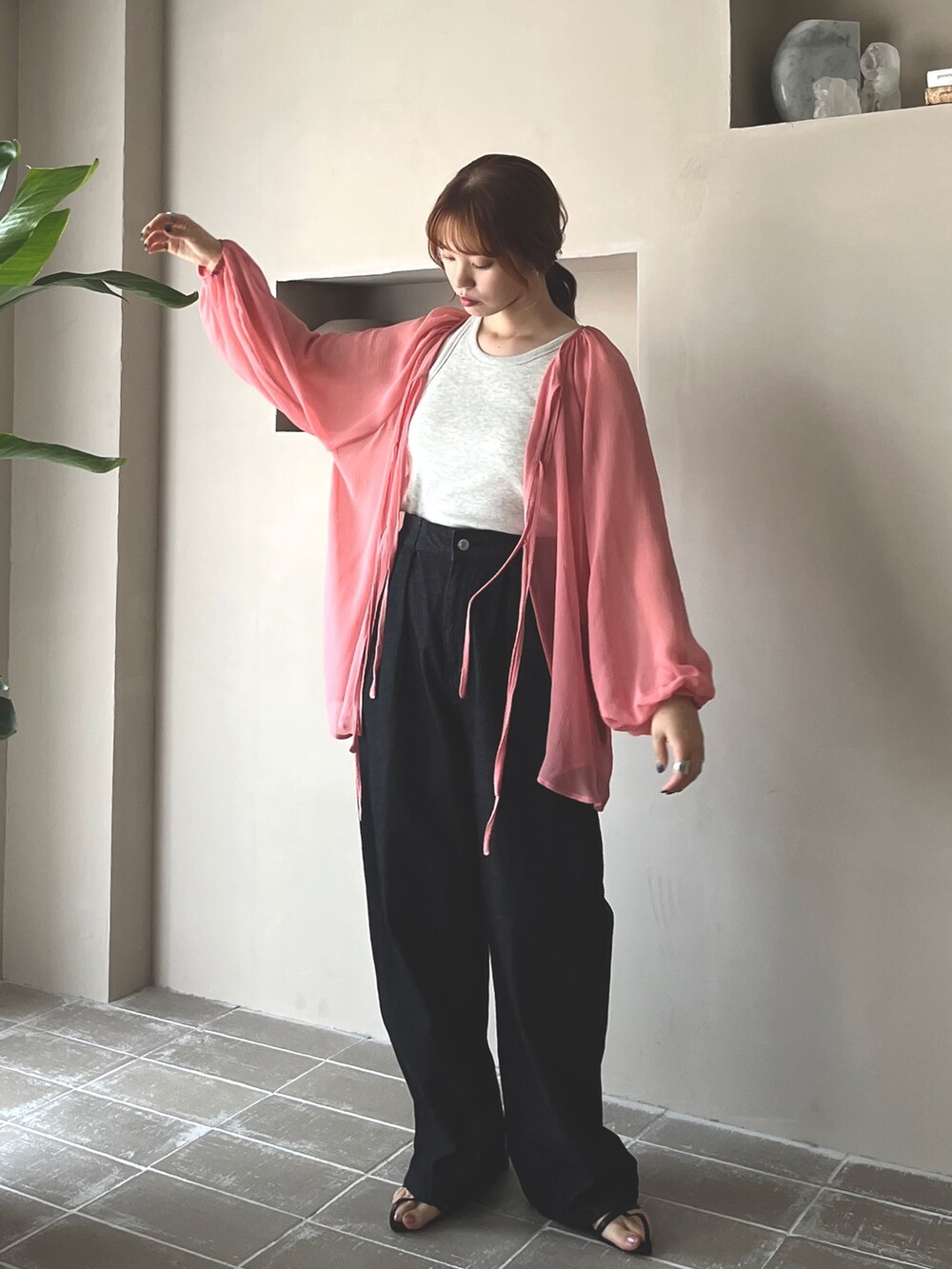 ブラック系のデニムパンツ、ブラック系のサンダル、ベージュ系のタンクトップを着用したレディースの春コーディネートの5枚目の写真