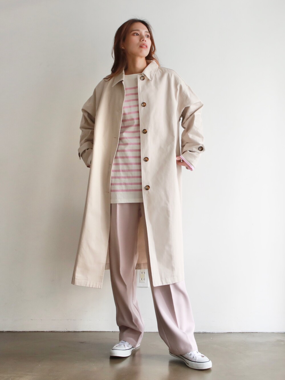 ホワイト系のステンカラーコート、ホワイト系のTシャツ/カットソー、ブラック系のハンドバッグを着用したレディースの冬コーディネートの4枚目の写真