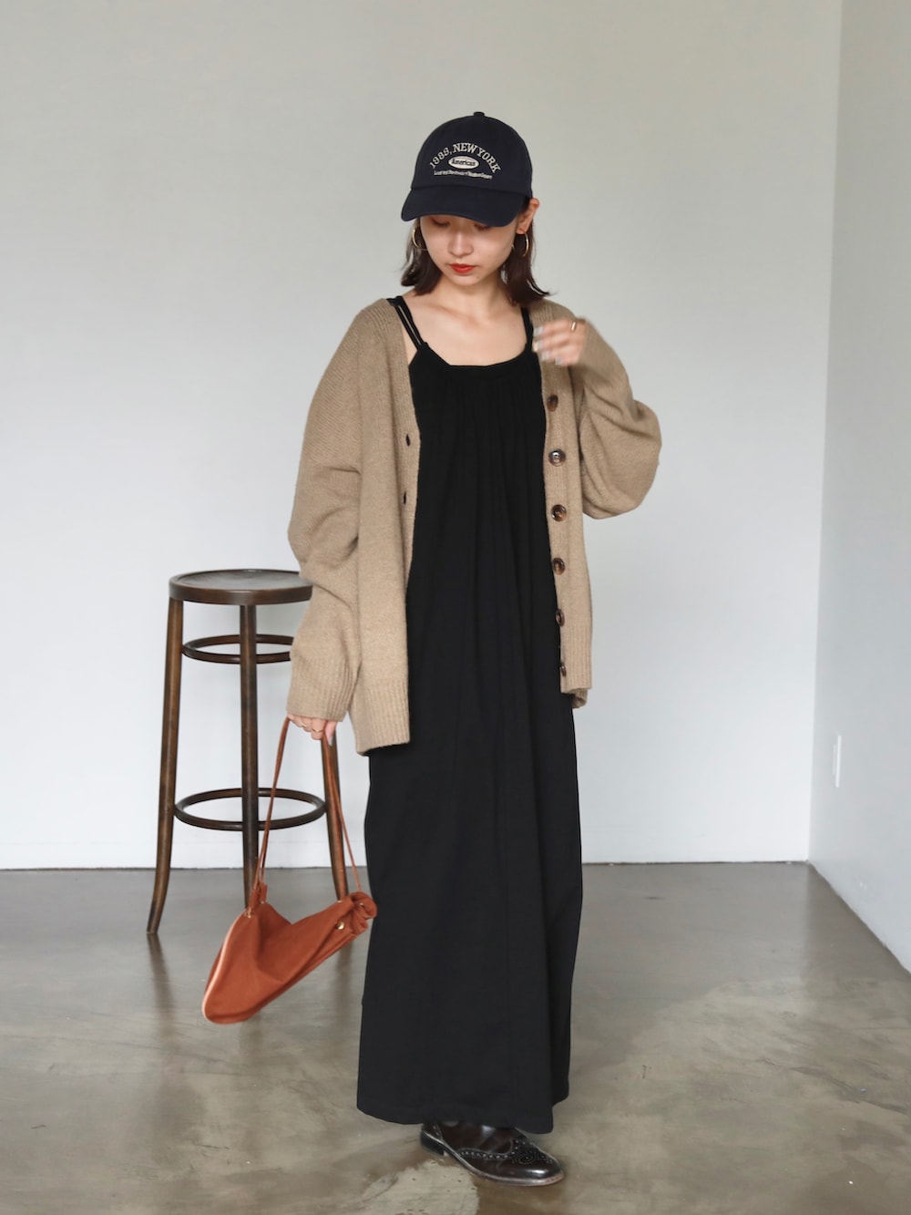 ブラック系のワンピース、ベージュ系のカーディガン/ボレロ、ブルー系のキャップを着用したレディースの夏コーディネートの3枚目の写真