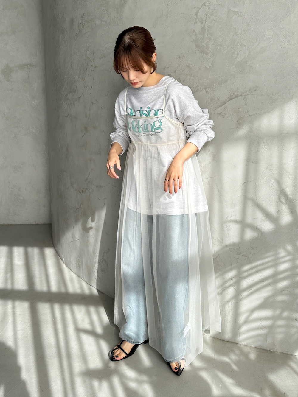 ホワイト系のワンピース、ベージュ系のスウェット、ブルー系のデニムパンツを着用したレディースの春コーディネートの2枚目の写真