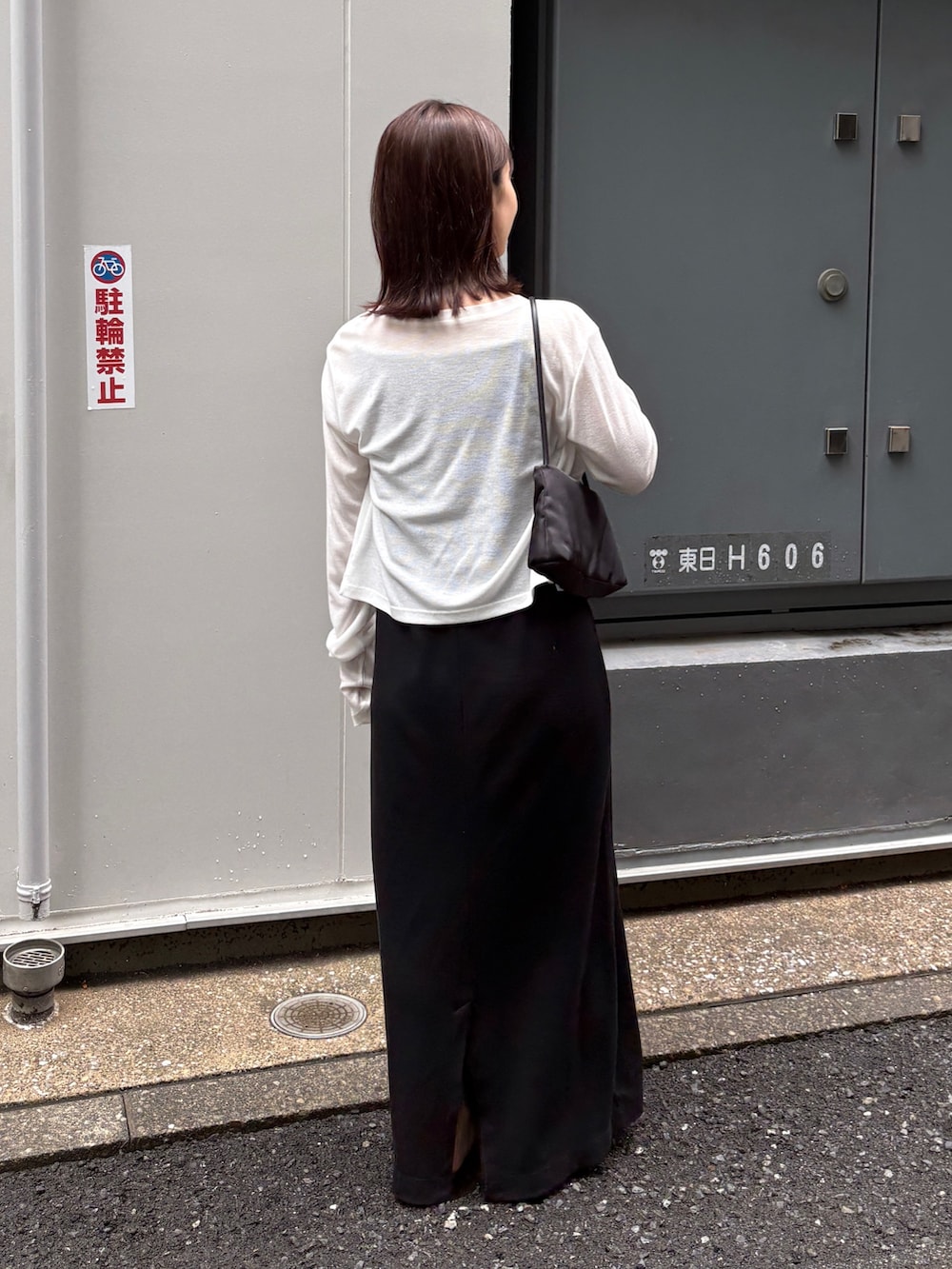 ブラック系のワンピース、ホワイト系のカーディガン/ボレロ、ブラック系のサンダルを着用したレディースの夏コーディネートの3枚目の写真
