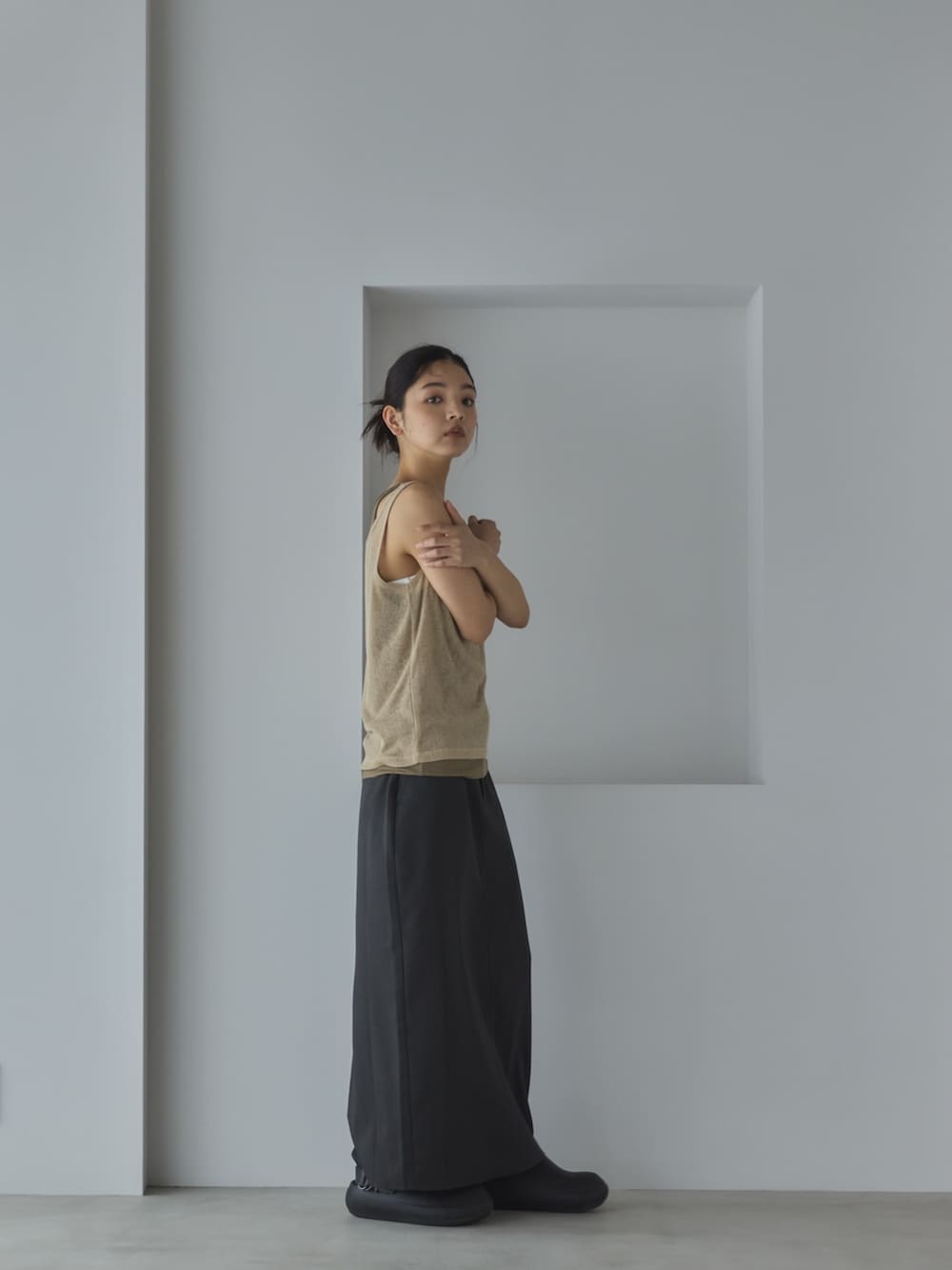 ベージュ系のタンクトップ、グレー系のスカート、ブラック系のサンダルを着用したレディースの春コーディネートの2枚目の写真