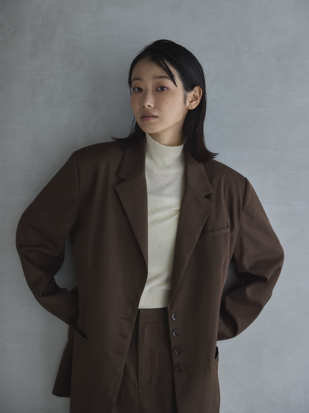 ホワイト系のデニムパンツ、ホワイト系のTシャツ/カットソー、ブラウン系のテーラードジャケットを着用したレディースの秋コーディネートの7枚目の写真