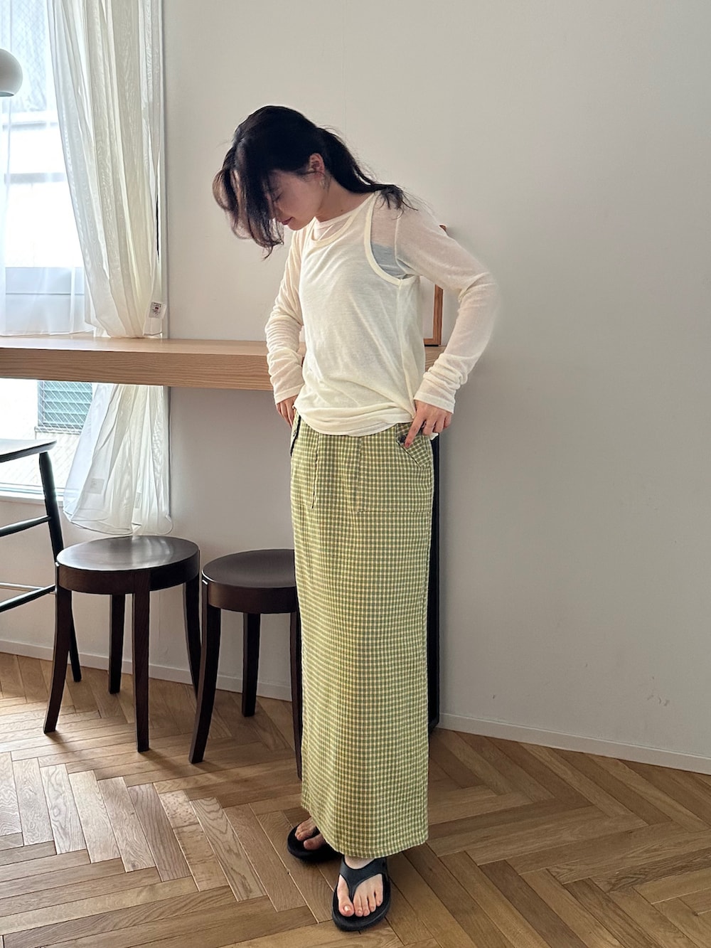 ホワイト系のTシャツ/カットソー、イエロー系のスカート、ブラック系のサンダルを着用したレディースの春コーディネートの2枚目の写真