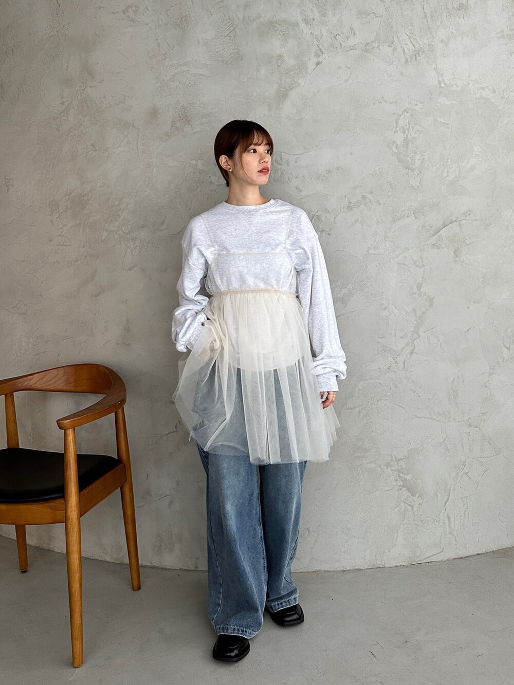 ベージュ系のスウェット、ホワイト系のシャツ/ブラウス、ブルー系のデニムパンツを着用したレディースの冬コーディネートの4枚目の写真