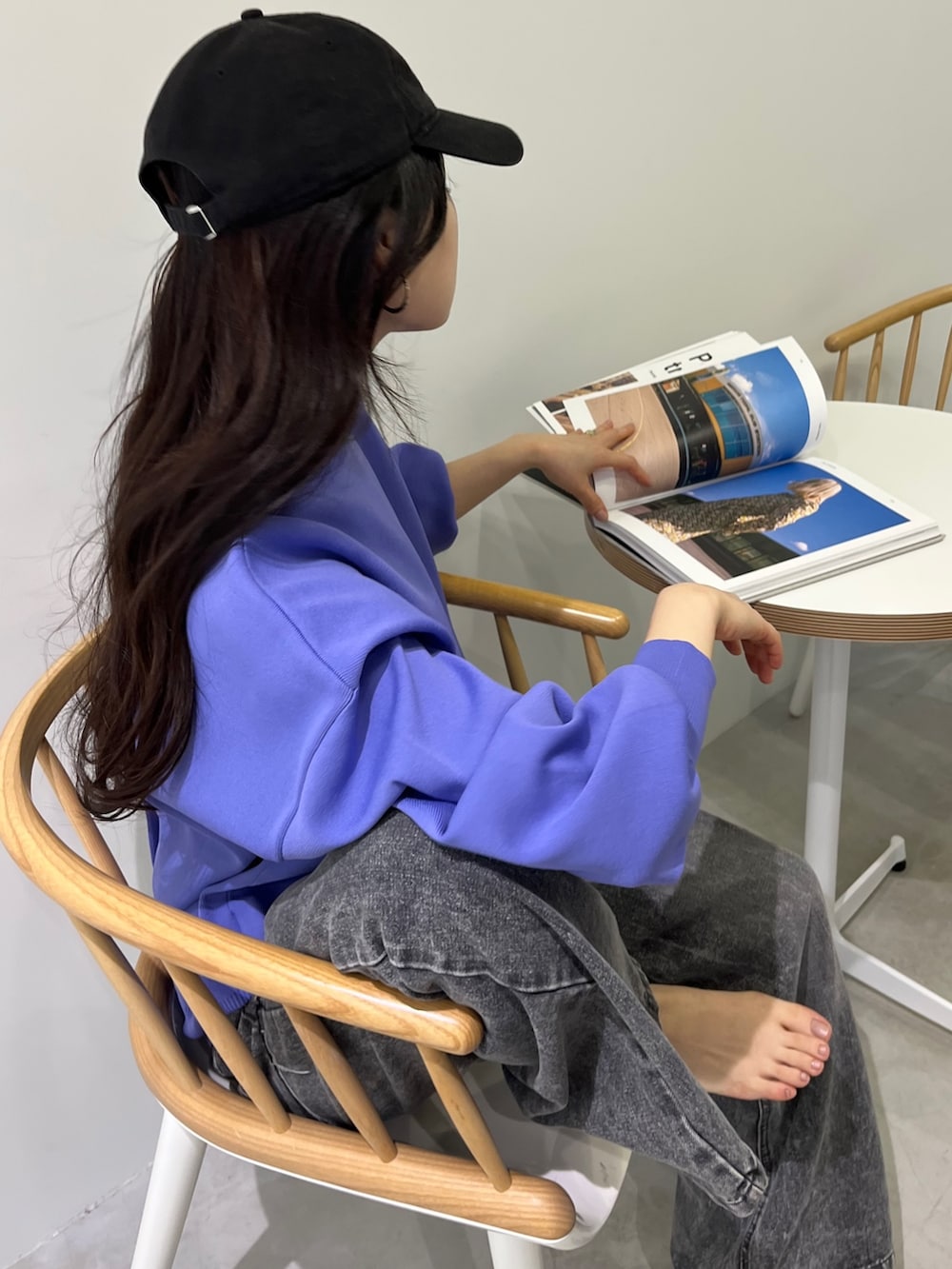 パープル系のカーディガン/ボレロ、ブラック系のデニムパンツ、グレー系のスニーカーを着用したレディースの冬コーディネートの3枚目の写真