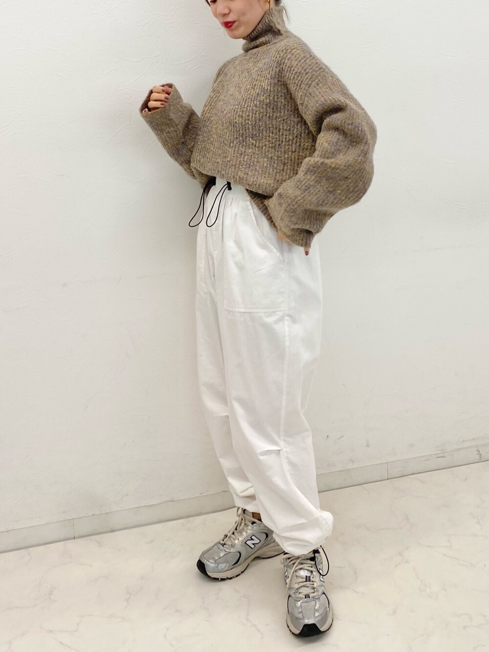 ホワイト系のカーゴパンツ、ホワイト系のスニーカー、ベージュ系のニット/セーターを着用したレディースの冬コーディネートの2枚目の写真
