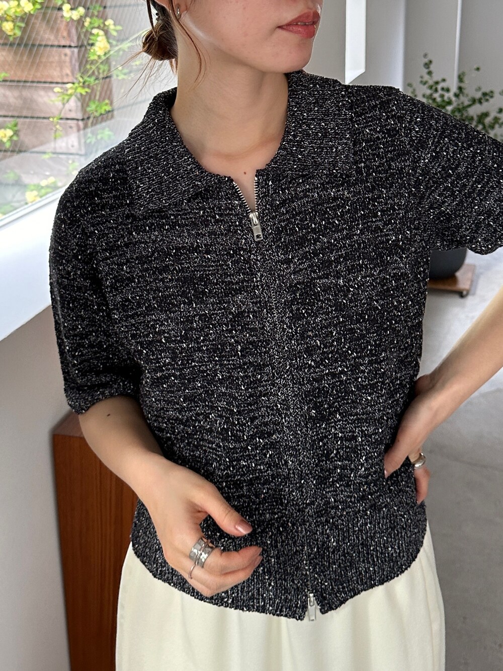 ブラック系のニット/セーター、ホワイト系のスカート、ブラック系のサンダルを着用したレディースの春コーディネートの3枚目の写真
