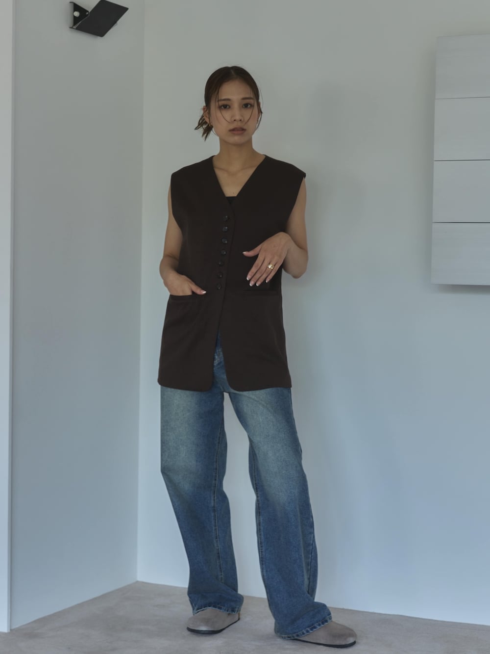 ブラウン系のベスト、ブルー系のデニムパンツ、ベージュ系のサンダルを着用したレディースの夏コーディネートの4枚目の写真