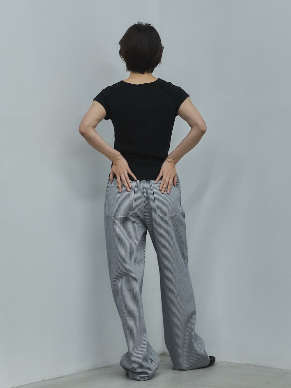 ブラック系のTシャツ/カットソー、ホワイト系のデニムパンツ、ブラック系のサンダルを着用したレディースの夏コーディネートの3枚目の写真