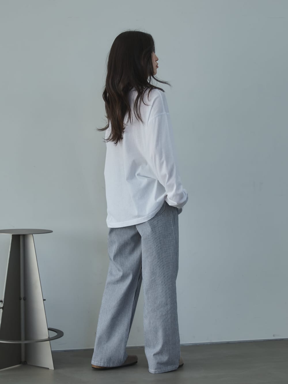 ホワイト系のTシャツ/カットソー、ホワイト系のデニムパンツ、ベージュ系のサンダルを着用したレディースの冬コーディネートの5枚目の写真