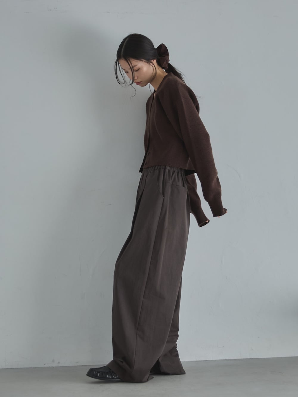 ブラウン系のカーディガン/ボレロ、ブラウン系のその他パンツ、ブラウン系のシュシュを着用したレディースの冬コーディネートの4枚目の写真