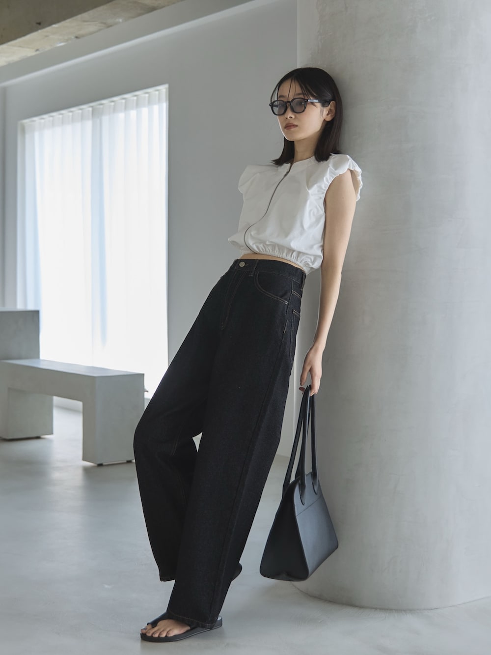 ブラック系のデニムパンツ、ホワイト系のシャツ/ブラウス、ブラック系のボストンバッグを着用したレディースの夏コーディネートの4枚目の写真