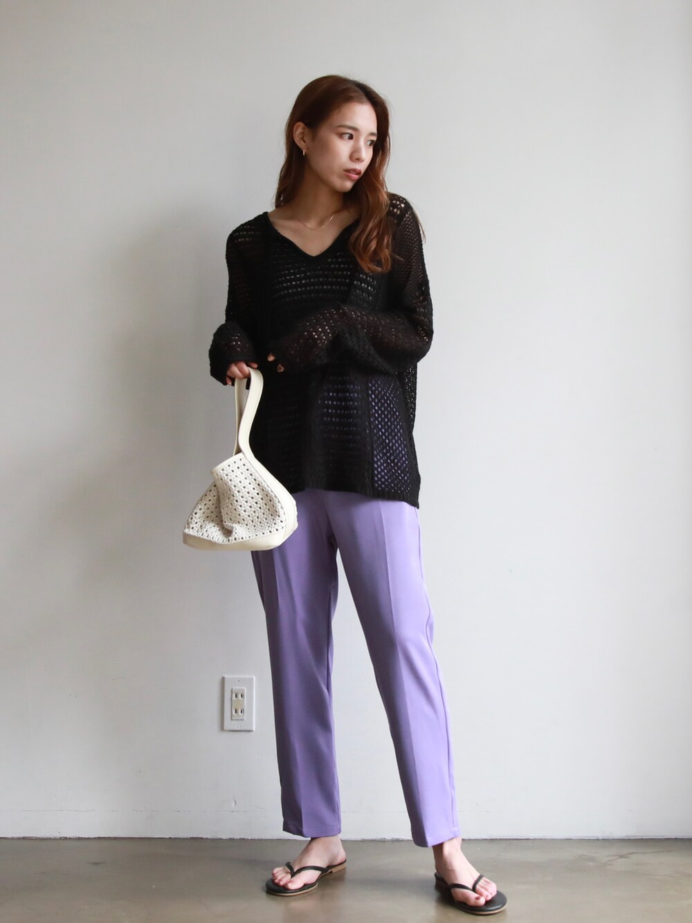 ピンク系のスラックス、ブラック系のニット/セーター、パープル系のスラックスを着用したレディースの春コーディネートの2枚目の写真