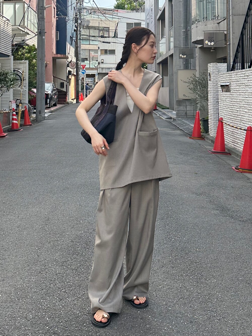 ベージュ系のその他トップス、ベージュ系のスラックス、ブラック系のトートバッグを着用したレディースの夏コーディネートの3枚目の写真