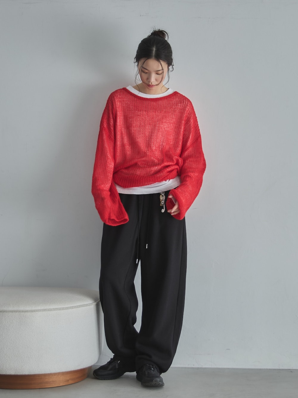 ホワイト系のTシャツ/カットソー、レッド系のニット/セーター、ブラック系のスウェットパンツを着用したレディースの冬コーディネートの5枚目の写真