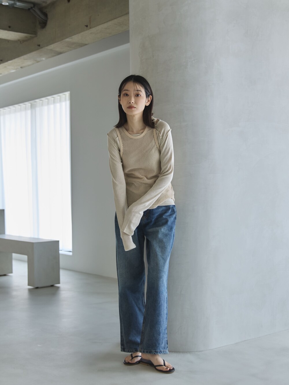 ベージュ系のTシャツ/カットソー、ベージュ系のタンクトップ、ブルー系のデニムパンツを着用したレディースの春コーディネートの3枚目の写真
