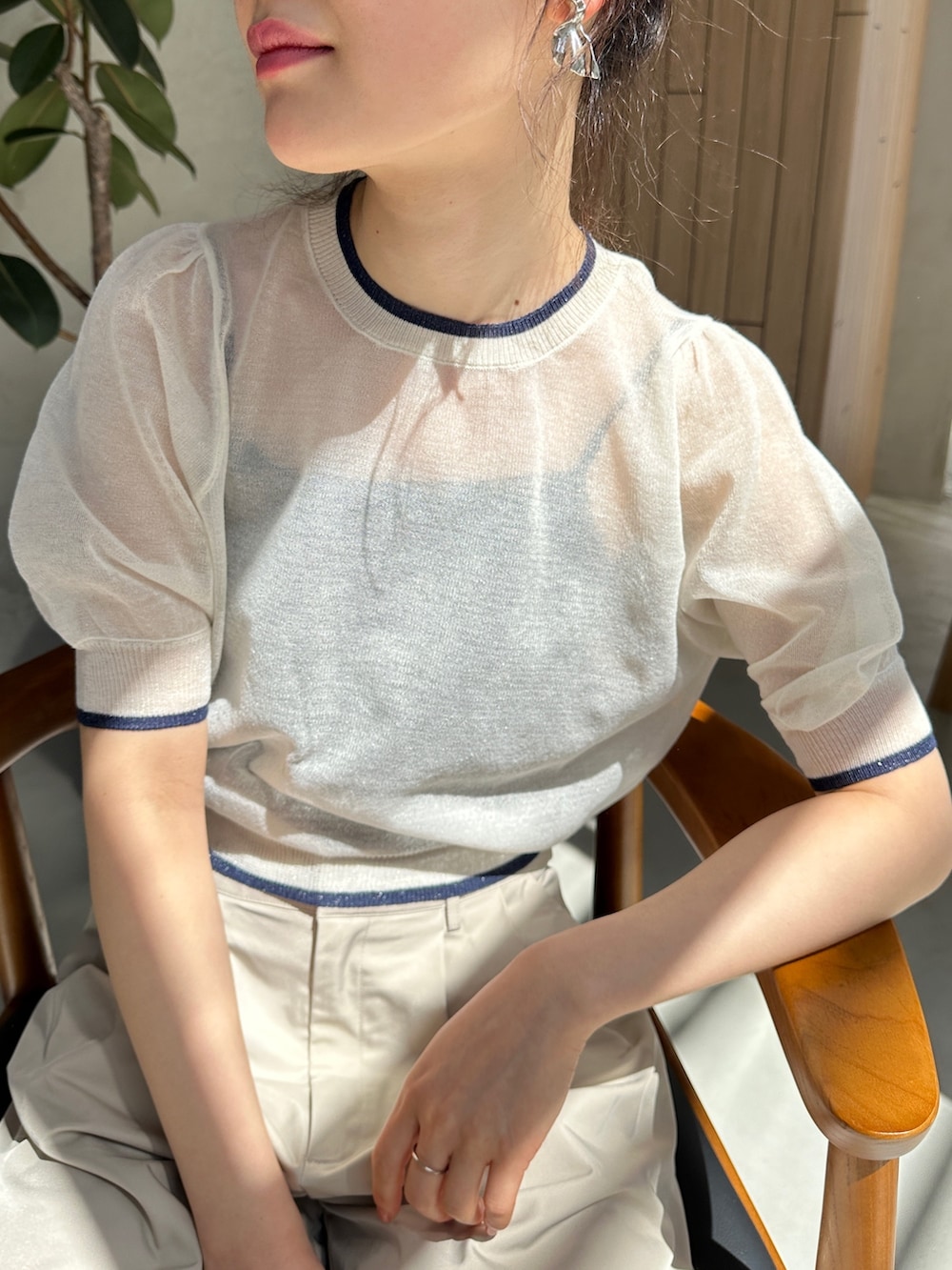 ホワイト系のニット/セーター、ベージュ系のその他パンツ、ブラック系のサンダルを着用したレディースの春コーディネートの3枚目の写真