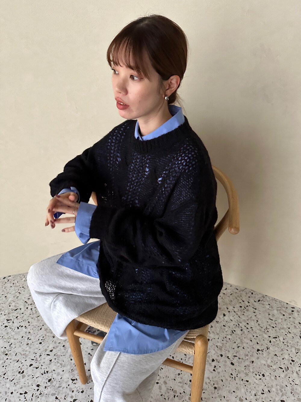 ブラック系のニット/セーター、ブルー系のシャツ/ブラウス、ベージュ系のスウェットパンツを着用したレディースの秋コーディネートの4枚目の写真