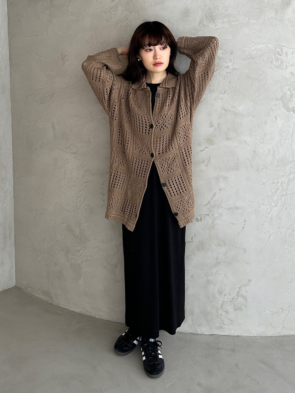 グリーン系のカーディガン/ボレロ、ブラック系のワンピース、ブラック系のスニーカーを着用したレディースの冬コーディネートの2枚目の写真