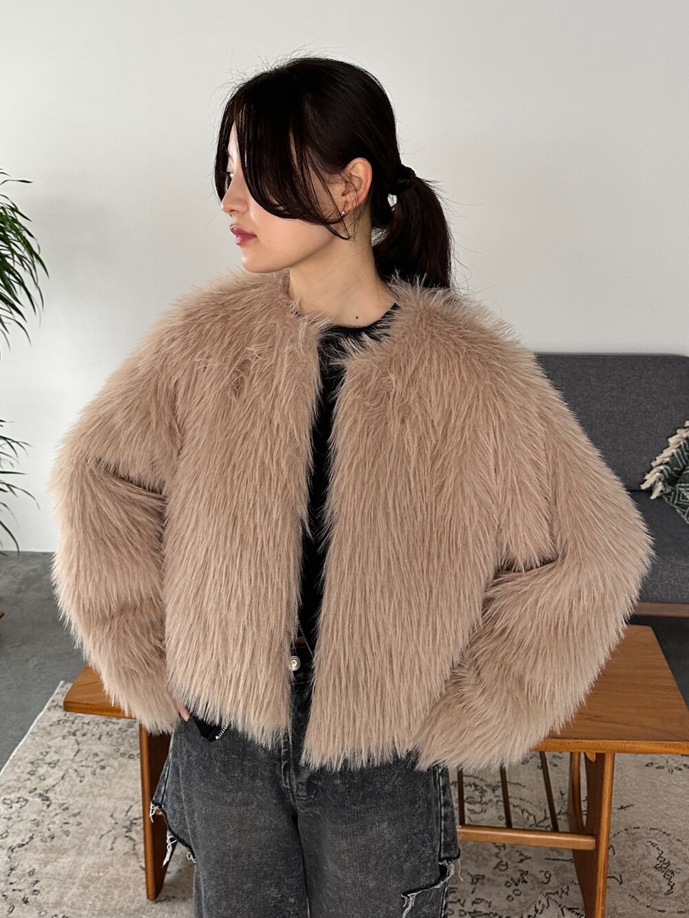 ブラック系のデニムパンツ、ベージュ系のその他アウター、ブラック系のニット/セーターを着用したレディースの冬コーディネートの4枚目の写真