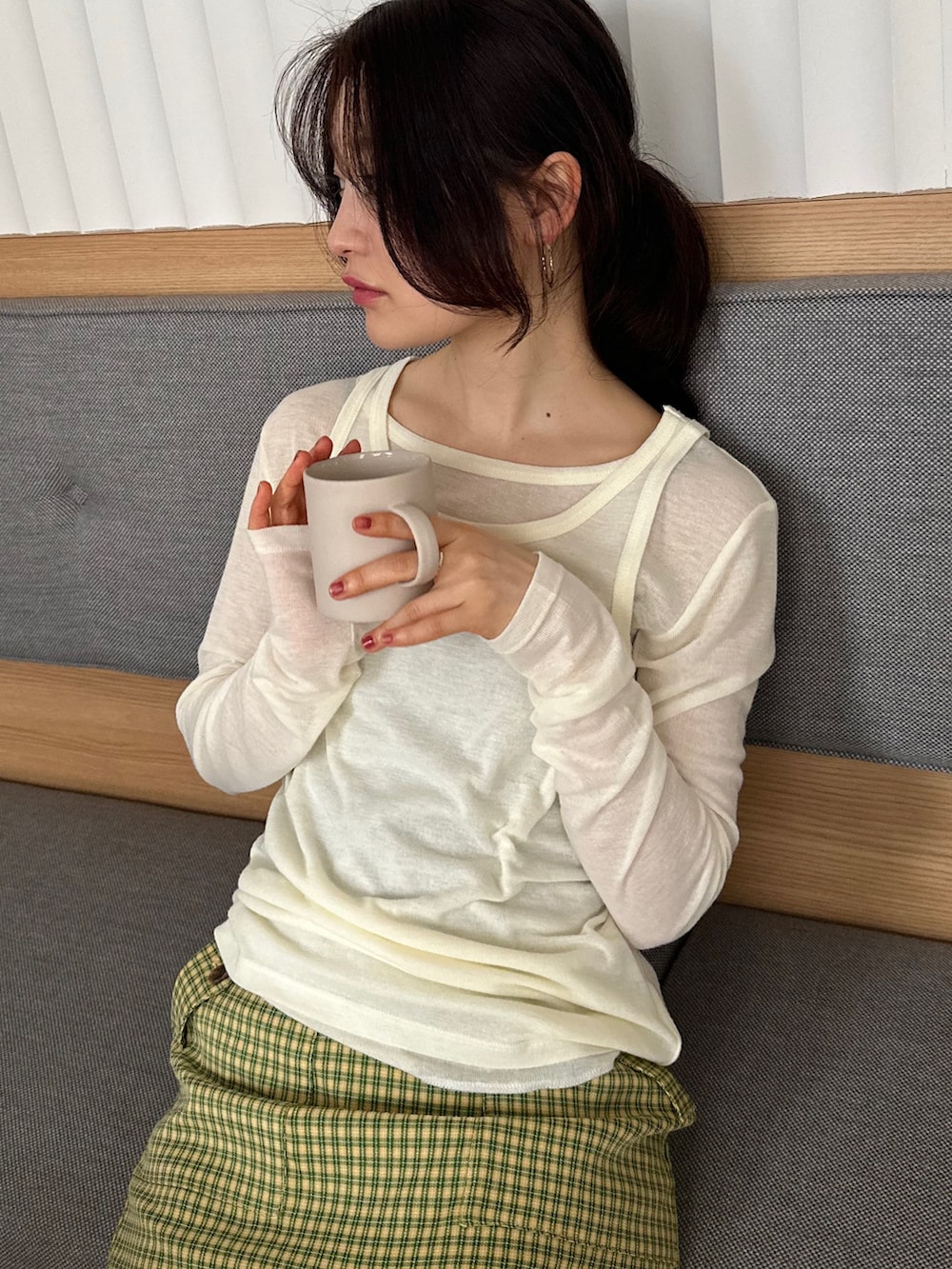 ホワイト系のTシャツ/カットソー、イエロー系のスカート、ブラック系のサンダルを着用したレディースの春コーディネートの3枚目の写真