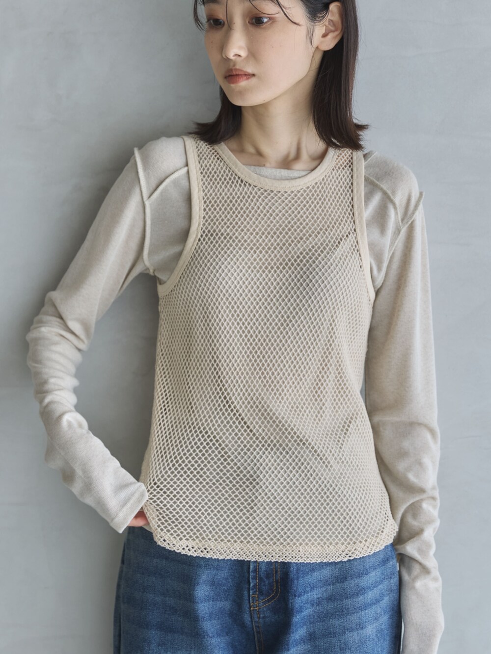 ベージュ系のTシャツ/カットソー、ベージュ系のタンクトップ、ブルー系のデニムパンツを着用したレディースの春コーディネートの4枚目の写真