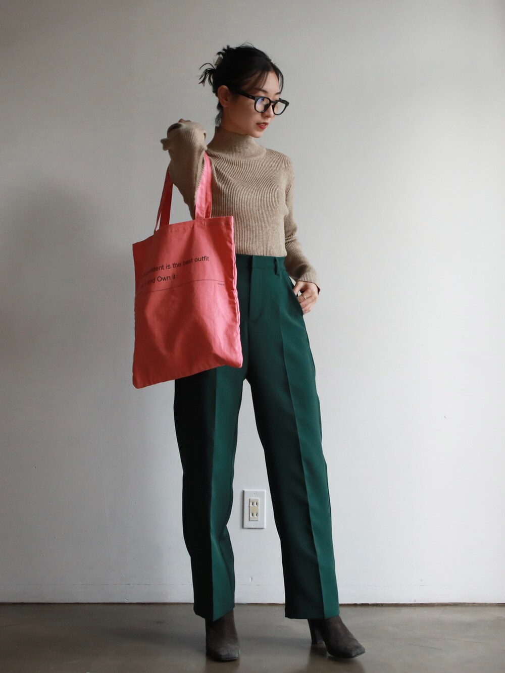 ブラウン系のハンドバッグ、ホワイト系のニット/セーター、ゴールド系のバレエシューズを着用したレディースの冬コーディネートの3枚目の写真