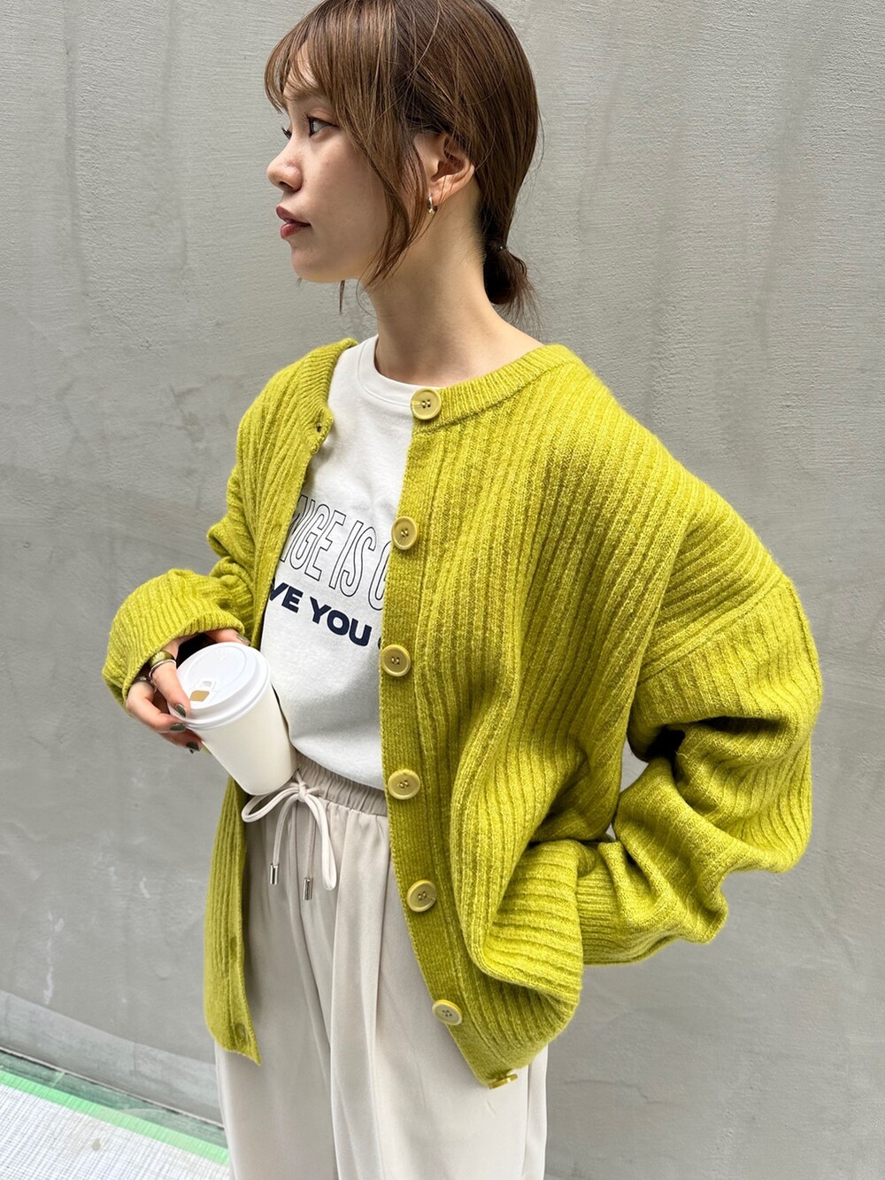 ホワイト系のスラックス、グリーン系のカーディガン/ボレロ、ホワイト系のTシャツ/カットソーを着用したレディースの夏コーディネートの3枚目の写真