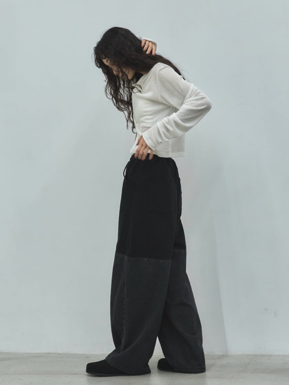 ブラック系のデニムパンツ、ブラック系のその他シューズ、ホワイト系のカーディガン/ボレロを着用したレディースの秋コーディネートの2枚目の写真