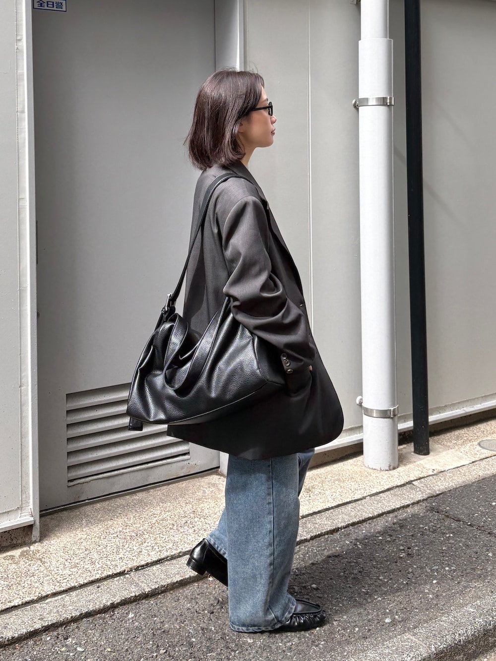 グレー系のテーラードジャケット、ホワイト系のTシャツ/カットソー、ブルー系のデニムパンツを着用したレディースの春コーディネートの2枚目の写真