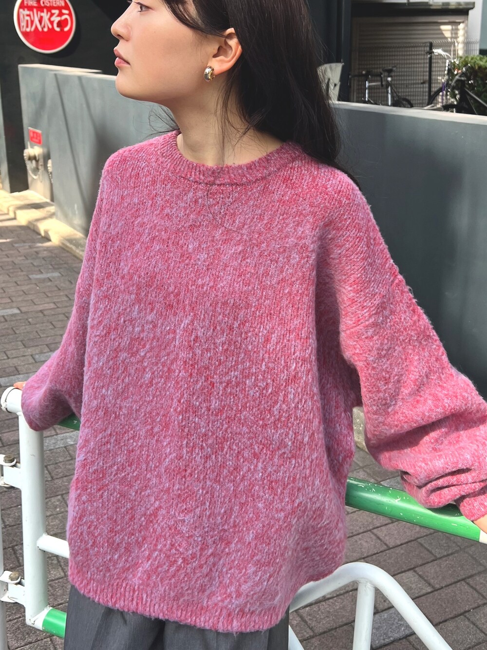 レッド系のニット/セーター、グレー系のスラックス、ブラック系のスニーカーを着用したレディースの秋コーディネートの4枚目の写真
