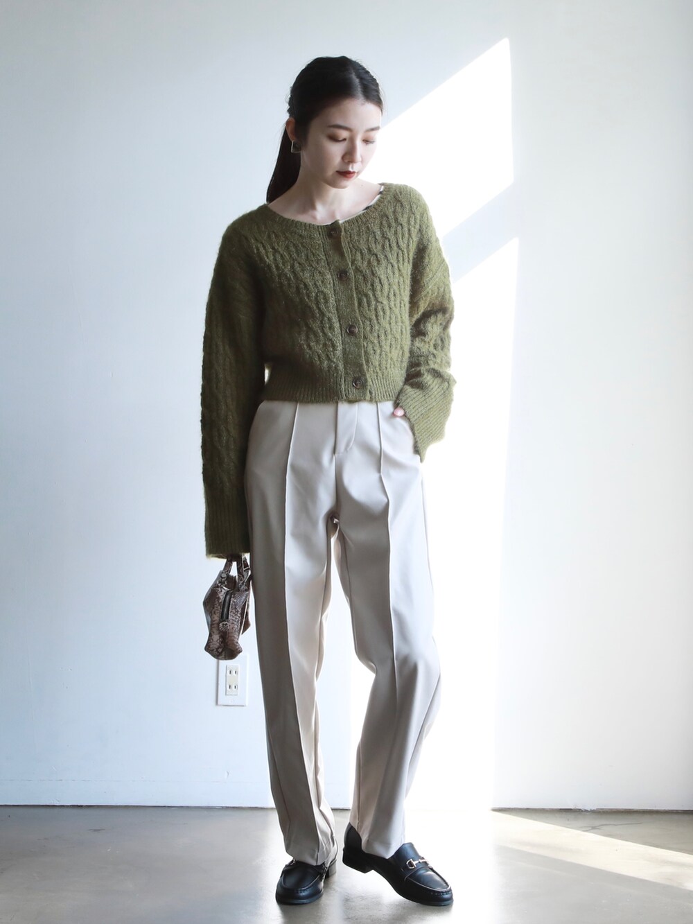 グリーン系のカーディガン/ボレロ、その他のショルダーバッグ、ホワイト系のニット/セーターを着用したレディースの冬コーディネートの4枚目の写真