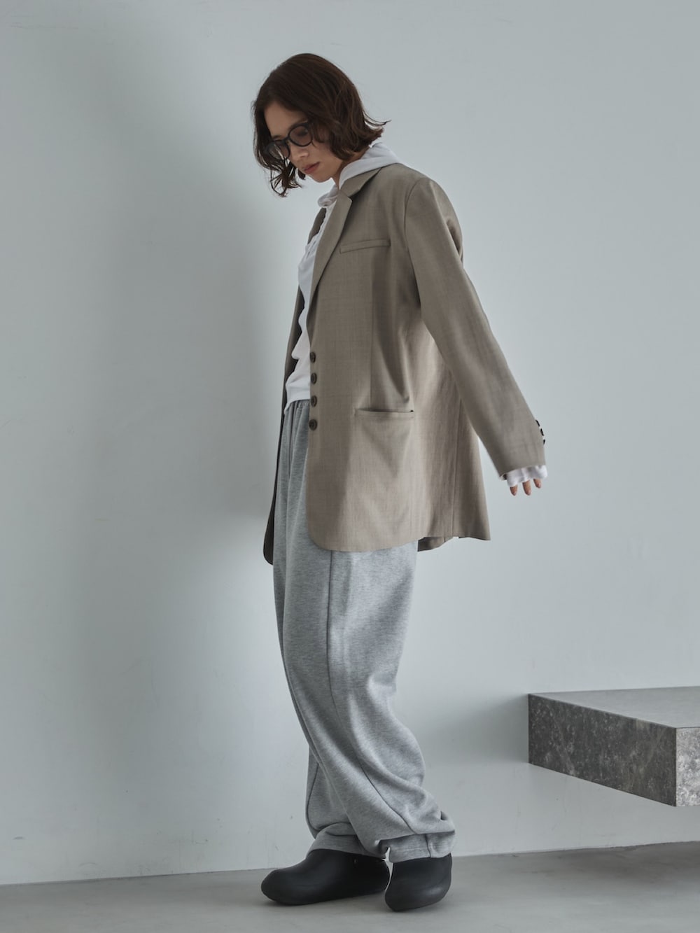 ベージュ系のテーラードジャケット、ホワイト系のTシャツ/カットソー、グレー系のスウェットパンツを着用したレディースの冬コーディネートの3枚目の写真