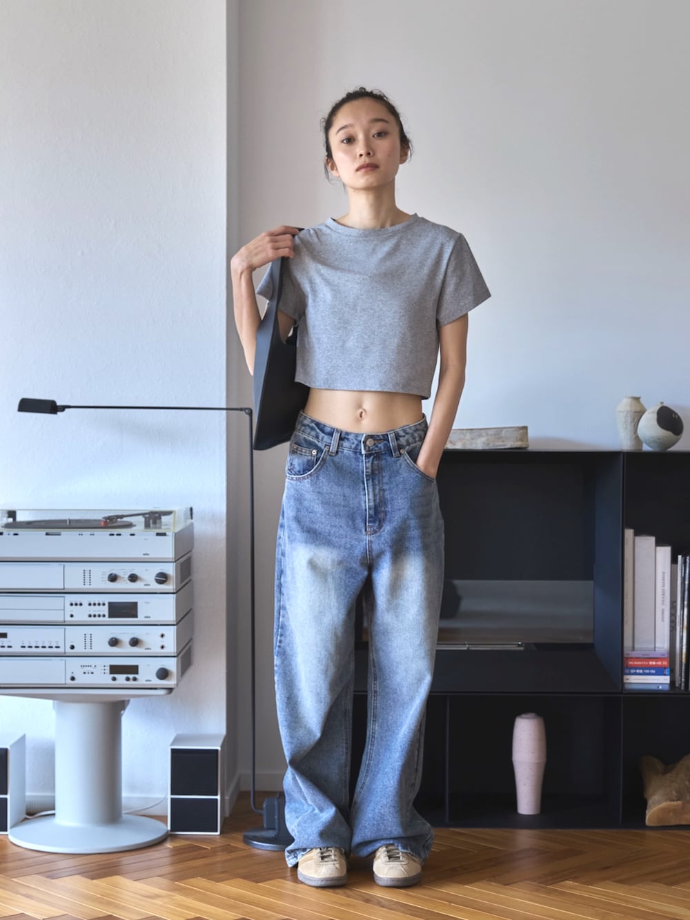 グレー系のTシャツ/カットソー、ブルー系のデニムパンツ、ベージュ系のスニーカーを着用したレディースの夏コーディネートの2枚目の写真