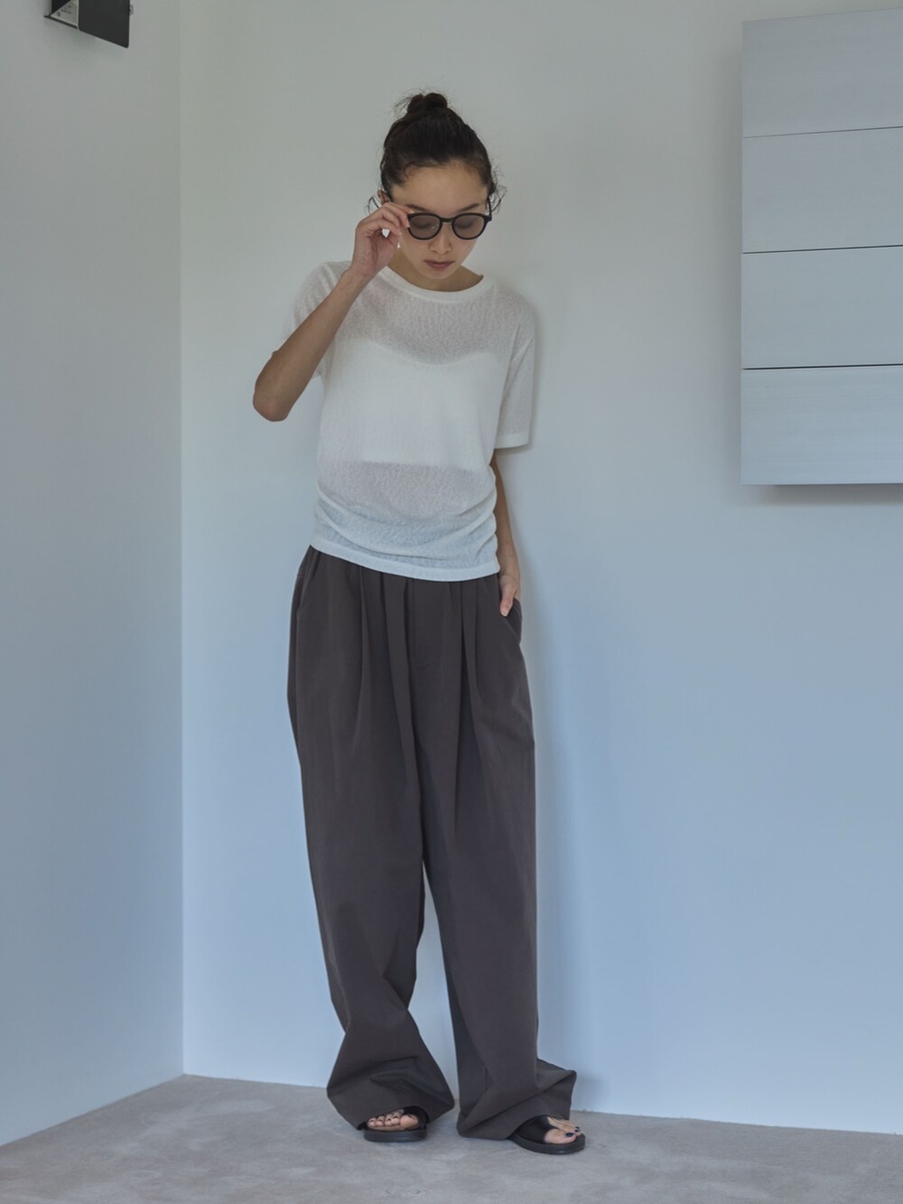 ホワイト系のTシャツ/カットソー、ブラウン系のその他パンツ、ブラック系のサンダルを着用したレディースの夏コーディネートの3枚目の写真